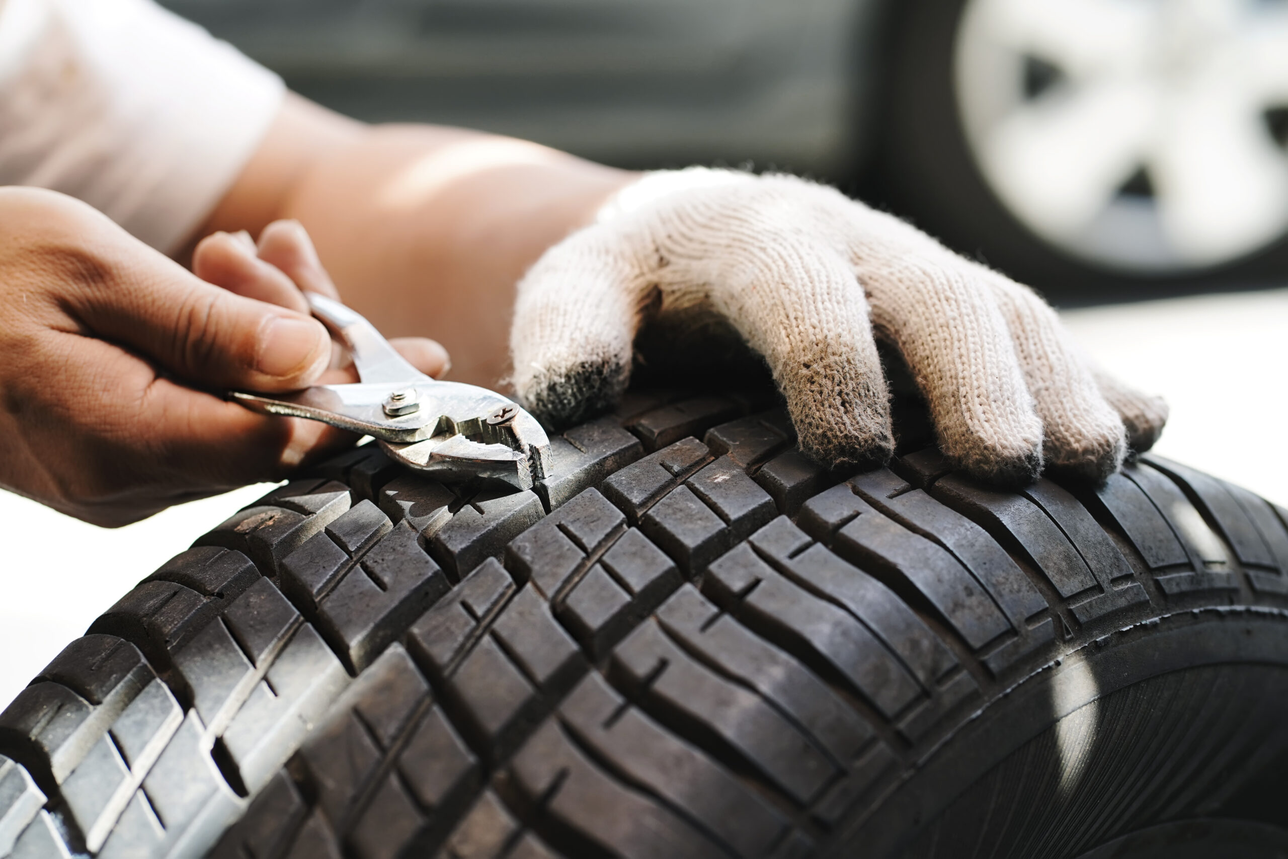 mechanic repair a tire puncture from a nail or screw. car repair and maintenance concept